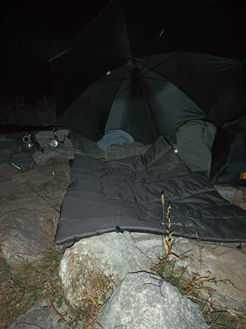 Schirm, Unterlage, Feederruten und Knicklichter beim Nachtangeln im September an einer Buhne