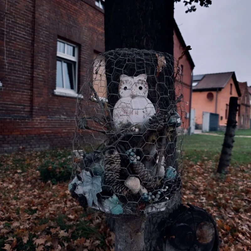 Dekorierte Eule an einem Baum im Vorgarten