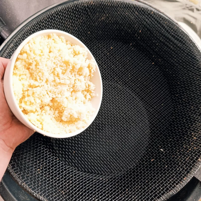 Couscous Angelfutterpartikel über einem Sieb