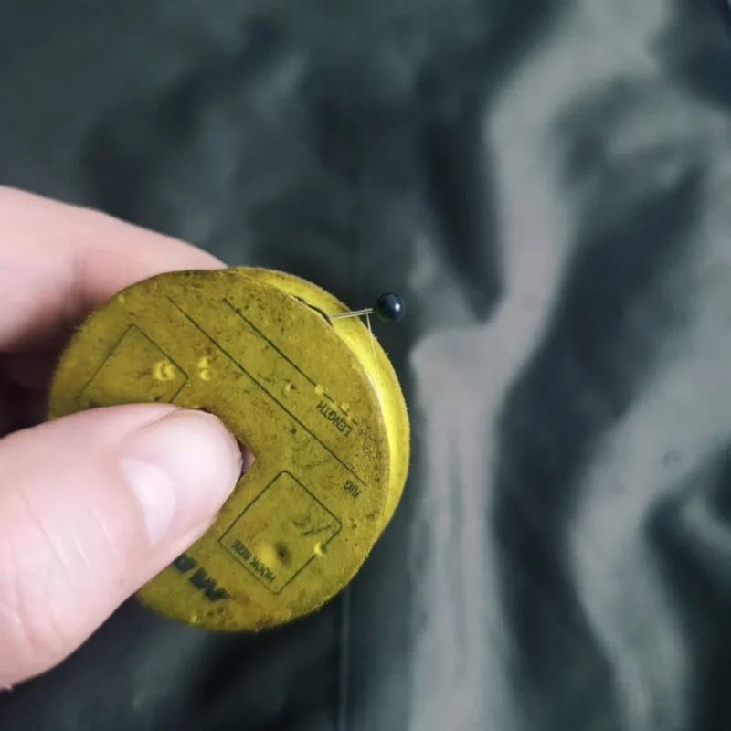 Steckkopfnadel in Schaumstoffrolle, das ein Feedervorfach fixiert