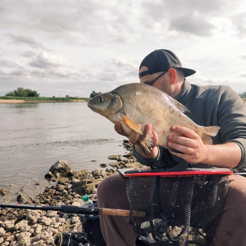 Christoph auf der Sitzkiepe beim Matchangeln an der Elbe mit gefangener Brasse 