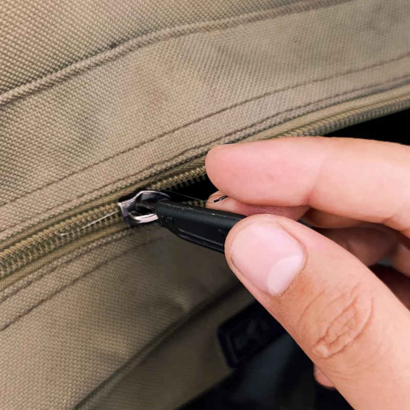 Haken dringt in Finger beim Verschließen des Rucksacks ein