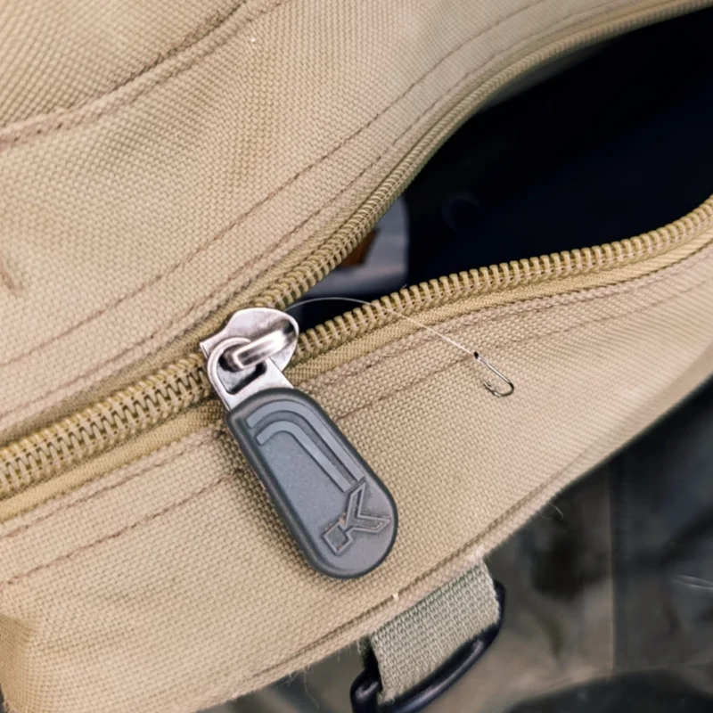 Haken mit Vorfach ragt aus der Rucksacktasche hervor
