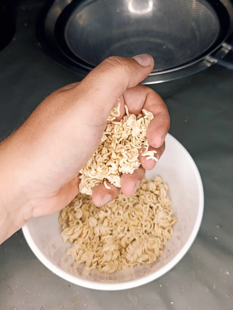 Schritt 1: Instantnudeln mit der Hand zerbröseln