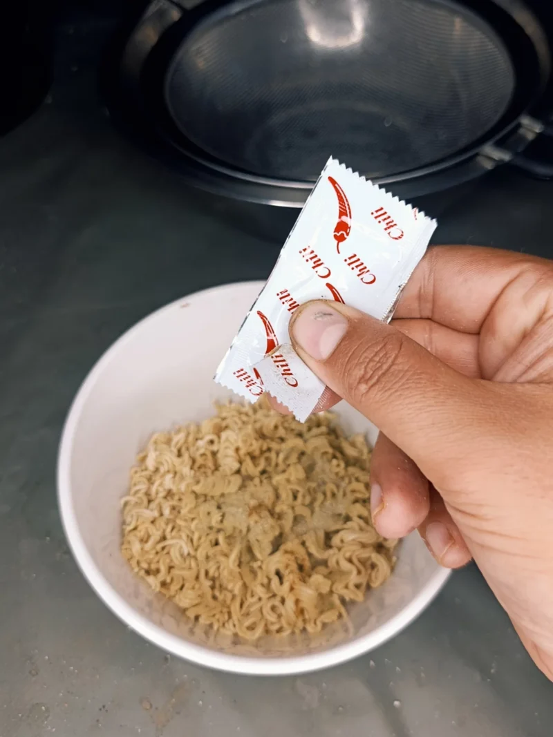 Schritt 2: Shrimparoma, Fett und Chili den Instantnudeln hinzugeben