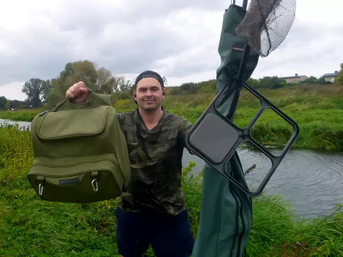Angler mit Ausrüstung zum Posenangeln am kleinen Fluss
