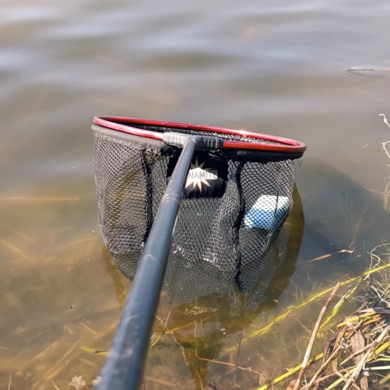 Schwamm im Kescherkopf über der Wasseroberfläche