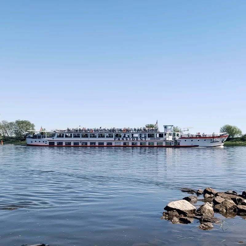 Schiff auf der Elbe fährt entlang der Fahrrinne