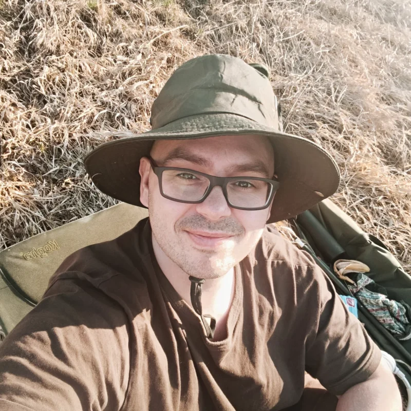 Christoph sitzt beim Method Feedern im März auf der Flussböschung