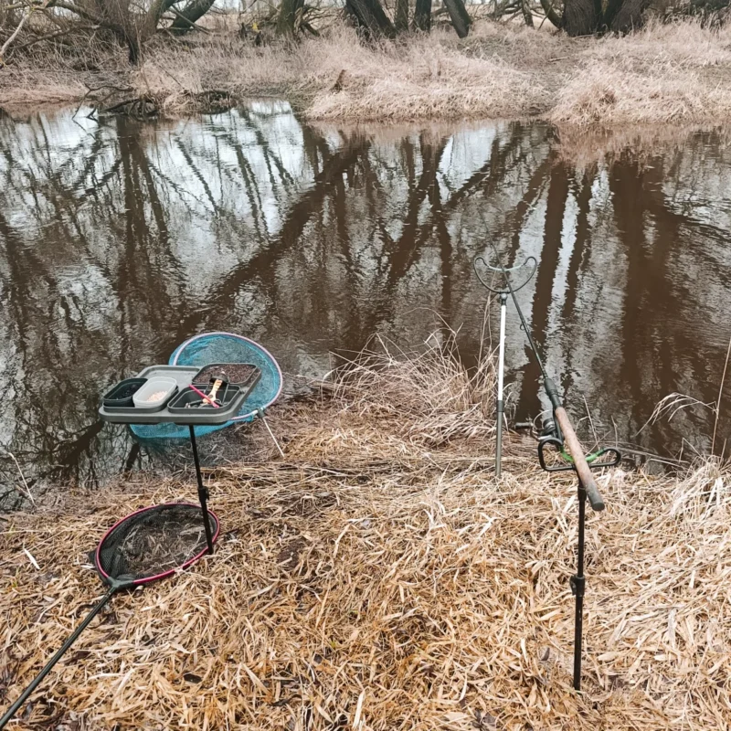 Winkelpicker, Kescherstab, Setzkescher und Winkelpicker am kleinen Fluss beim Angeln auf Rotaugen im Februar