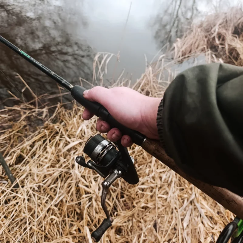 Angler mit der Hand am Rutengriff