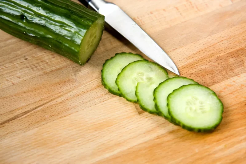 Salatgurke in Scheiben geschnitten auf einem Holzbrett