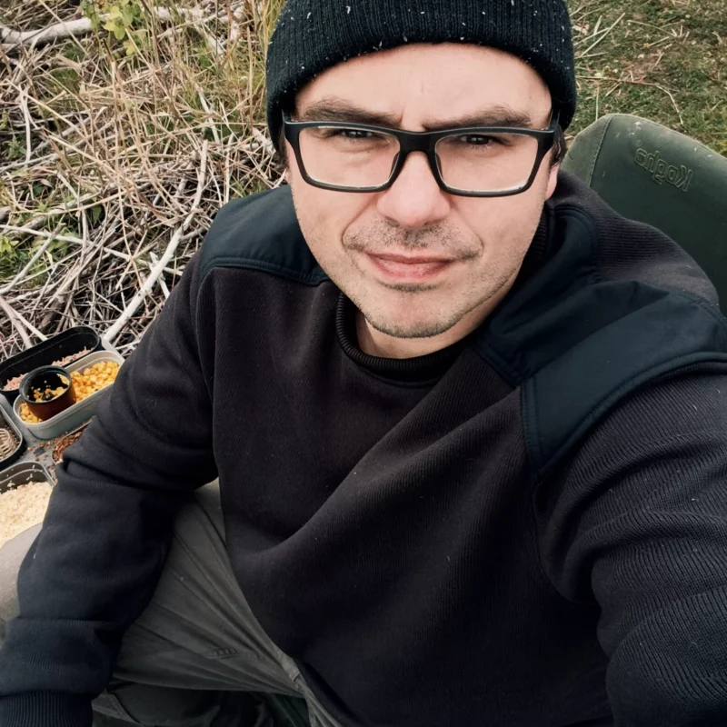 Christoph sitzt in Gedanken beim Angeln auf seinem Angelstuhl